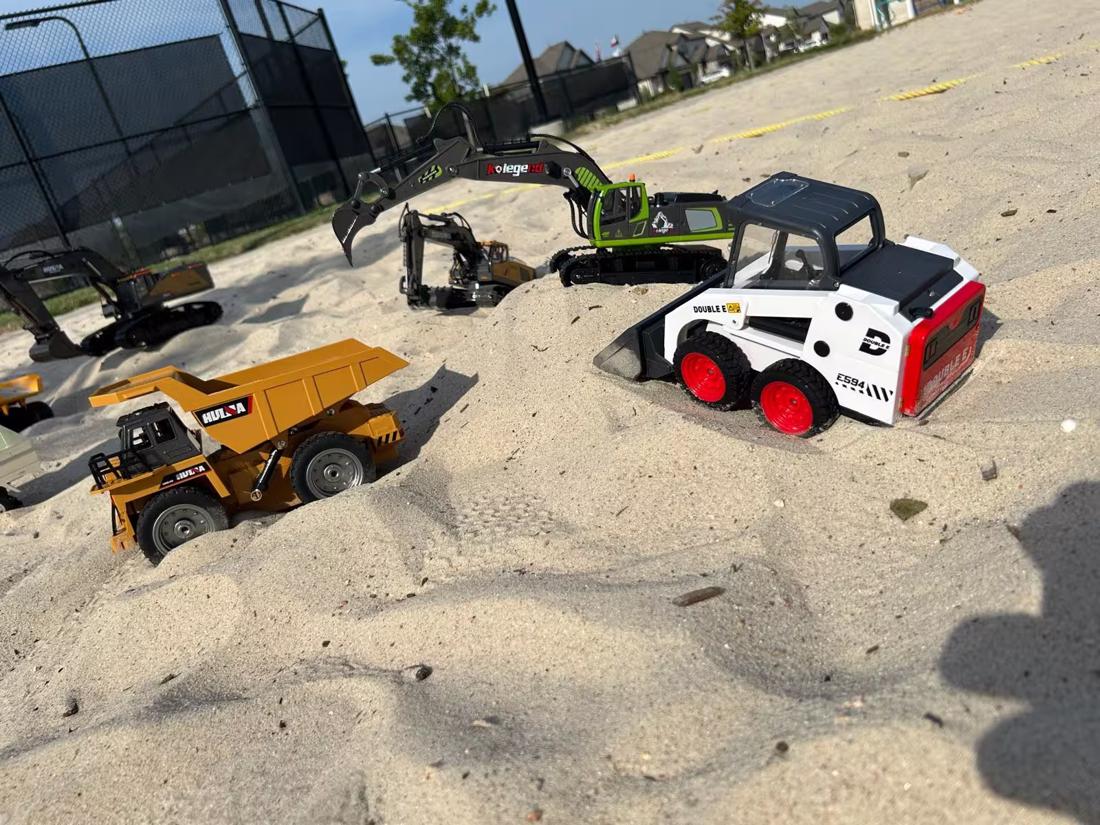 Close-up of an RC excavator digging in the mobile sandbox pit.